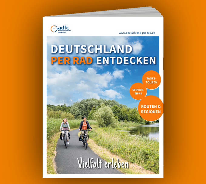 Neue Ausgabe: Deutschland per Rad entdecken Zwei Radfahrerinnen auf einem asphaltierten Radweg durch eine naturbelassene Flusslandschaft